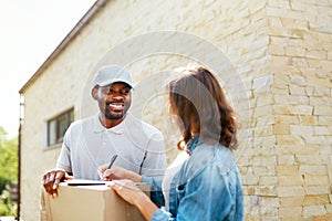 Package Delivery. Man Courier Delivering Box To Woman At Home