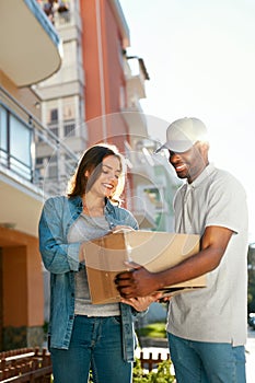 Package Delivery. Man Courier Delivering Box To Woman At Home