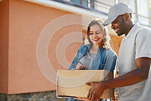 Package Delivery. Man Courier Delivering Box To Woman At Home photo