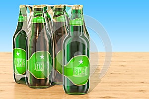 Package of glass beer bottles in shrink film on the wooden table