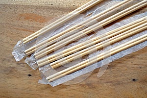 Package of readymade bamboo chopsticks on wooden background