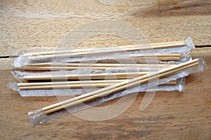 Package of readymade bamboo chopsticks on wooden background photo