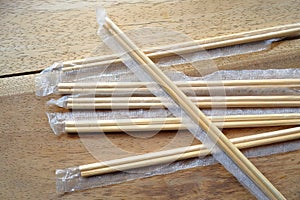 Package of readymade bamboo chopsticks on wooden background photo