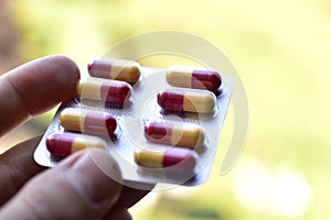 Package of red and yellow pills in the afternoon on the background of the window