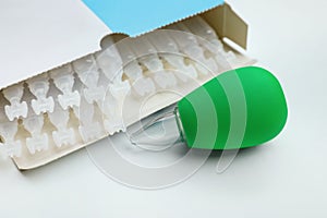 Package with single dose ampoules of sterile isotonic sea water solution and nasal aspirator on white background, closeup