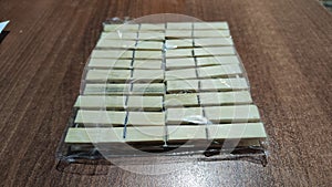Package of wooden white clothespins on a brown wooden surface photo