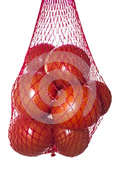 Packaged tomatoes hanging in red plastic net