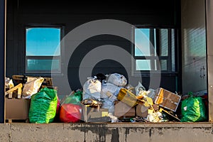 Packaged waste for landfilling. Garbage bags and boxes on the loading dock. Waste removal.