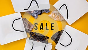 Packaging bags, text Big sale on yellow background Top view Flat lay sesonal sale, retail, shopping concept