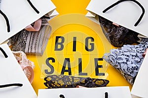 Packaging bags, text Big sale on yellow background Top view Flat lay sesonal sale, retail, shopping concept