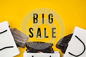 Packaging bags, text Big sale on yellow background Top view Flat lay sesonal sale, retail, shopping concept
