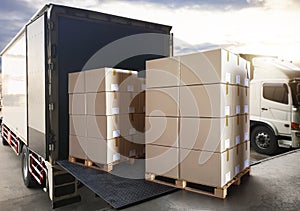 Packaging Boxes Stack on Pallets Loading into Cargo Container. Shipping Trucks. Supply Chain Shipment Boxes. Distribution Supplies