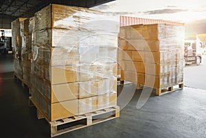 Packaging Boxes Stacked Wrapped Plastic on Pallets Loading with Shipping Cargo Container. Delivery Trucks Loading Dock Warehouse.