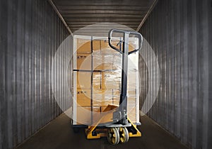 Packaging Boxes Wrapped Plastic Stacked on Pallet with Hand Pallet Truck. Inside Shipping Cargo Container. Loading Trucks.