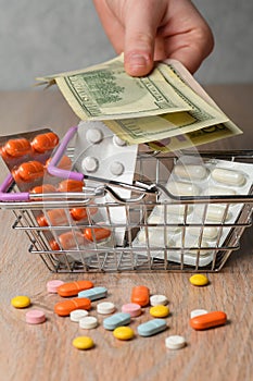 Packaging of medical tablets in the shopping cart. Scattered pills and money. The concept of buying pills.