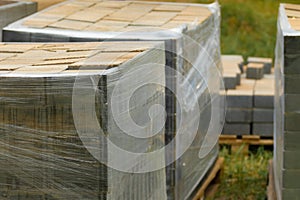 Packaging of new paving slabs. Cement tiles wrapped with stretch film for transportation. Selective focus. Construction Materials