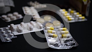 Packaging of tablets and pills on black background