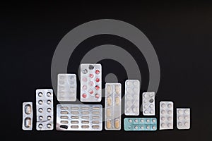 Packaging of tablets and pills on black background. Drug prescription for treatment medication. Pharmaceutical medicament, cure i