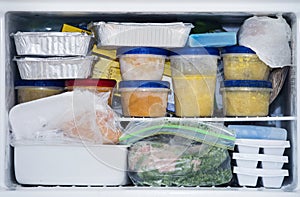 A packed freezer with soup and chicken