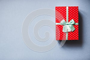 Packed red present with bow on blue background.
