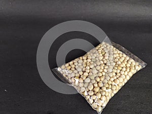 Packet of pea seeds on black background