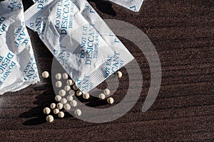 packets of desiccant scattered on a dark surface