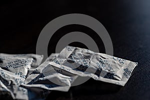 packets of desiccant scattered on a dark surface