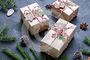 Packing Christmas gifts. Christmas gift boxes and decorations, pine branches on dark table.