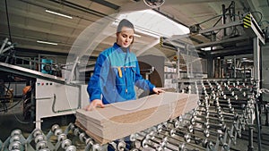 Packing factory. The worker inspects the finished package on the conveyor. Box