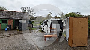 Packing a home removals van truck full of furniture on a farm courtyard