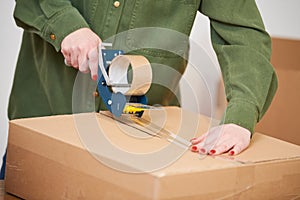 packing a parcel. sealing carton box with tape for shipping