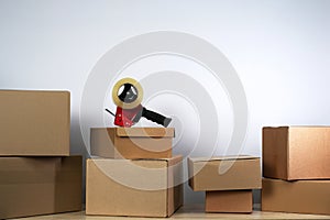 Packing tape dispenser and cardboard boxes and on white background