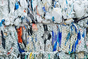 Packs and Stocks of Wrapped Scrap Plastic Dedicated for Eco Recycling in front of a Recycling Factory