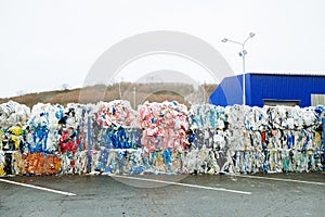 Packs and Stocks of Wrapped Scrap Plastic Dedicated for Eco Recycling in front of a Recycling Factory