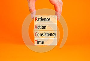 PACT patience action consistency time symbol. Concept words PACT patience action consistency time on blocks on orange background.