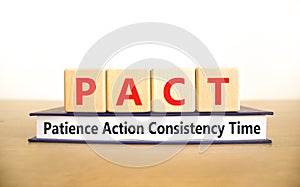 PACT patience action consistency time symbol. Concept words PACT patience action consistency time on blocks on white background.