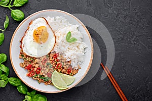 Pad Krapow Gai - Thai Basil Chicken with Rice and fried Egg black slate background. Pad Krapow is Thai cuisine dish