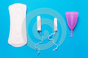 Pad, menstrual cup, tampon on a blue background. photo