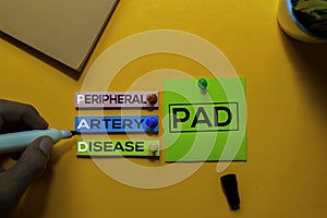 PAD. Peripheral Artery Disease acronym on sticky notes. Office desk background photo