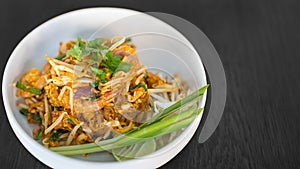 Pad thai coriander on top juicy creamy tasty delicious world popular. Thai famous food menu close up in bowl on black wood table