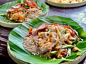 Pad Thai, the famous Thai food menu noodle stir-fried cook with egg, pork, long bean and peanut, put on banana leaf plate.