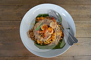 Pad Thai with shrimp, Thai cuisine on wooden table