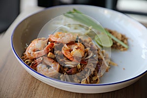 Pad thai with shrimp on wooden table , Thai food