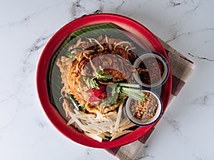 Pad Thai Soft Shell Crab noodle with red chilli in a dish isolated on mat top view on grey marble background