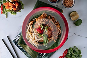 Pad Thai Soft Shell Crab noodle with red chilli in a dish isolated on mat top view on grey marble background