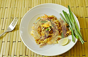 Pad Thai stir fried rice noodles with dry shrimp and yellow tofu on plate