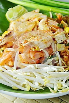 Pad Thai stir fried rice noodles with seafood and egg on plate