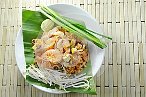 Pad Thai stir fried rice noodles with seafood and egg on plate