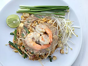 Pad Thai, stir-fried rice noodles with shrimp in white dish on white background. The one of Thailand's national main dish. th