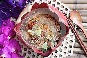 Pad Thai - Thai famous stir fry noodle in banana blossom bowl on bamboo placemat